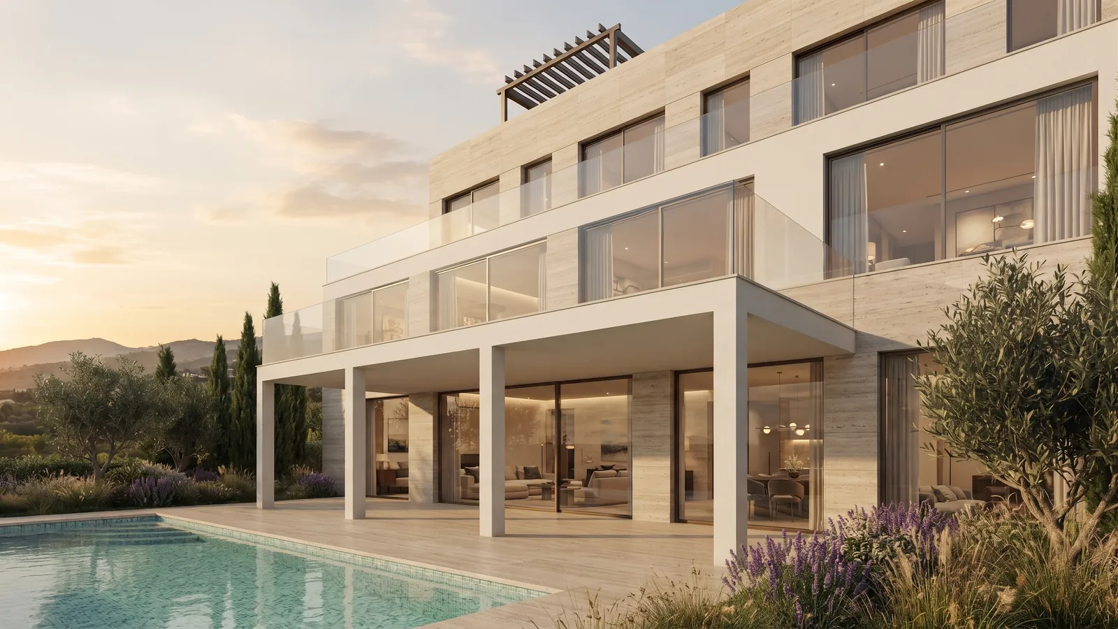 South façade of residence V01 at golden hour: travertine walls, glazed living level opening onto the pool terrace, olive trees and lavender. Render.